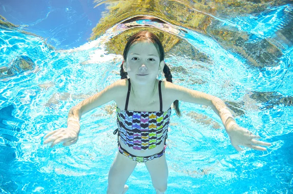 Los niños nadan en la piscina bajo el agua, la chica activa feliz se divierte en el agua, el deporte infantil en vacaciones familiares — Foto de Stock