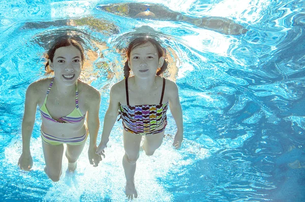 Barnen bada i pool underwater, glada aktiva tjejer ha kul i vatten, barn sport på familjesemester — Stockfoto