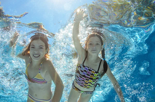 Kinder schwimmen im Pool unter Wasser, fröhliche aktive Mädchen haben Spaß im Wasser, Kindersport im Familienurlaub — Stockfoto