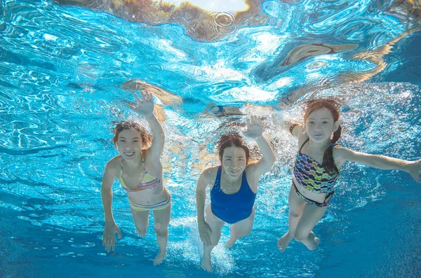 Nadar en familia en la piscina o el mar bajo el agua, madre activa feliz y los niños se divierten en el agua, el deporte de los niños en vacaciones familiares — Foto de Stock