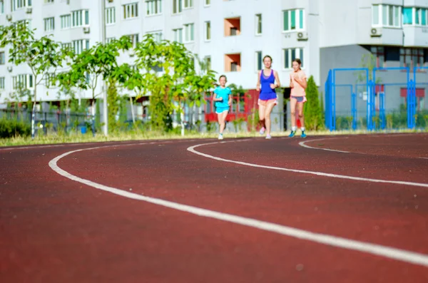 Familiensport, glückliche aktive Mutter und Kinder joggen auf der Bahn, laufen und trainieren im Stadion in der modernen Stadt — Stockfoto