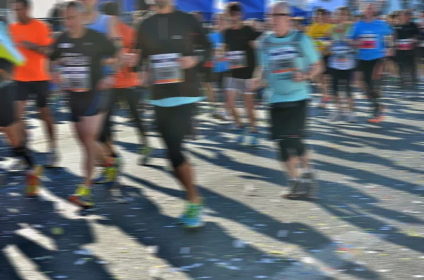 Fundo desfocado: maratona corrida, corredores na estrada, esporte, fitness e conceito de estilo de vida saudável — Fotografia de Stock