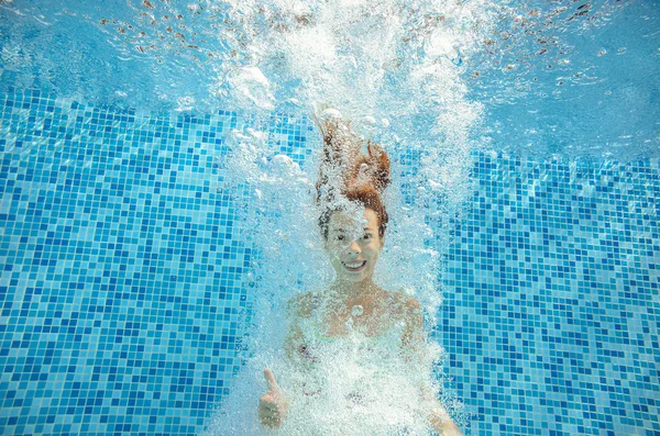 Dziewczynka skacze i pływa w basenie pod wodą, szczęśliwy, że aktywne dziecko ma zabawy w wodzie, sport dziecko na rodzinne wakacje — Zdjęcie stockowe