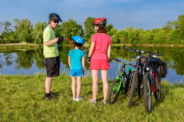 家族自転車乗るアウトドア、アクティブな親と子供のサイクリング、美しい川の近くリラックス — ストック写真