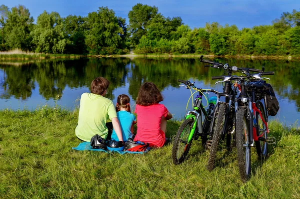 Family bike ride outdoors, active parents and kid cycling and relaxing near beautiful river — Stock Photo, Image