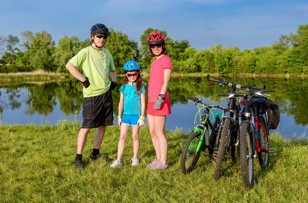 Familjen cykel rida utomhus, aktiva föräldrar och kid cykling och avkopplande nära vackra floden — Stockfoto