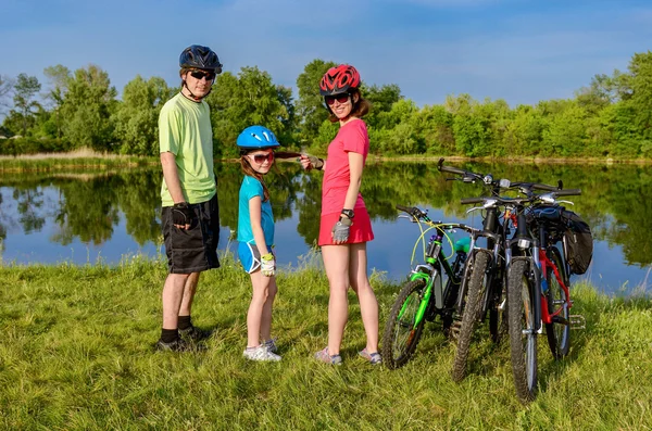 Paseo en bicicleta familiar al aire libre, padres activos y ciclismo infantil y relajarse cerca del hermoso río — Foto de Stock