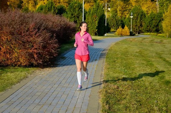 Frauenlauf im Herbstpark, schöne Läuferin beim Joggen im Freien, Training für Marathon, Bewegungs- und Fitnesskonzept — Stockfoto