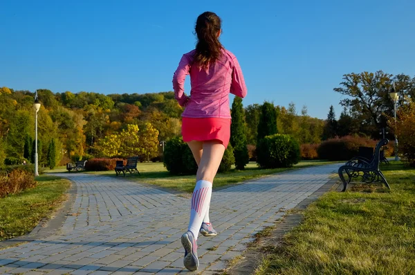 Mujer corriendo en el parque de otoño, hermosa corredora corriendo al aire libre, entrenamiento para maratón, ejercicio y concepto de fitness —  Fotos de Stock