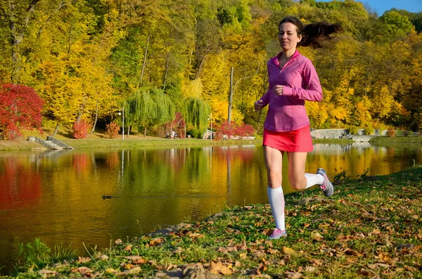 Donna che corre nel parco autunnale, bella ragazza corridore che corre all'aperto, allenamento per la maratona, esercizio e concetto di fitness — Foto Stock