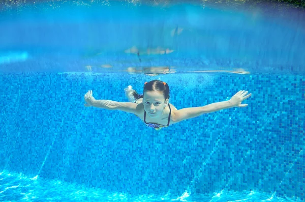 Criança nada na piscina subaquática, menina ativa feliz se diverte na água, esporte infantil em férias em família — Fotografia de Stock