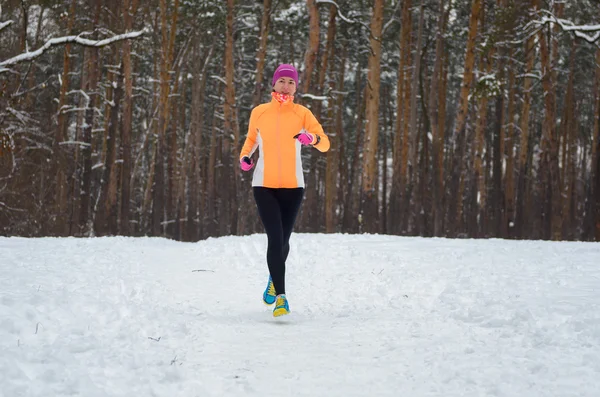 Winter met in forest: gelukkig vrouw loper joggen in de sneeuw, buiten sport en fitness concept — Stockfoto