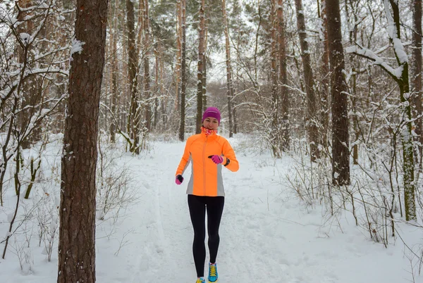 Zima w lesie: szczęśliwa kobieta lekkoatletka jogging w śniegu, odkryty sport i fitness koncepcja — Zdjęcie stockowe