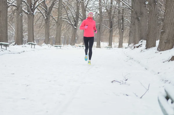 Winter running in park: happy woman runner jogging in snow, outdoor sport e fitness concept — Foto Stock