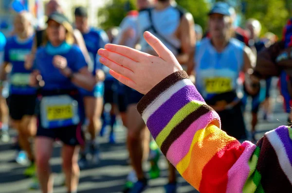 Verschwommener Hintergrund: Marathonlauf, Unterstützungsläufer auf der Straße, Kinderhände geben Highfive, Sportkonzept — Stockfoto