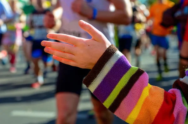 Fond flou : course de marathon, coureurs de soutien sur la route, main d'enfant donnant highfive, concept sportif — Photo