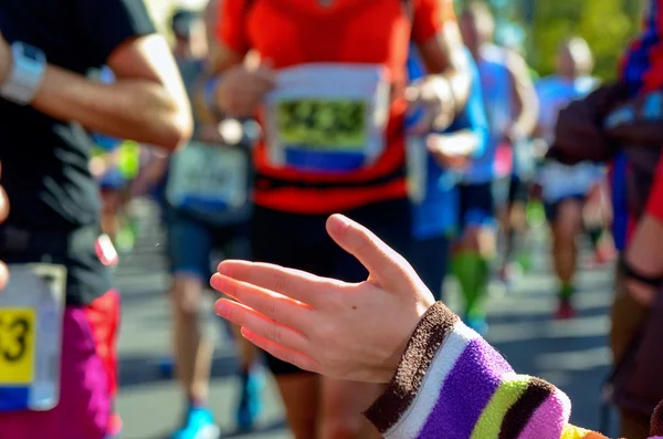 Verschwommener Hintergrund: Marathonlauf, Unterstützungsläufer auf der Straße, Kinderhände geben Highfive, Sportkonzept — Stockfoto