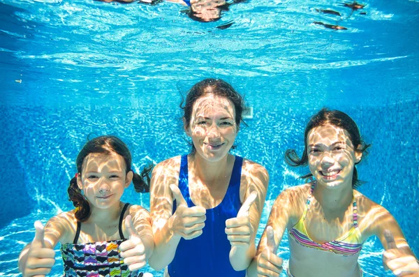 Family swim in pool underwater, happy active mother and children have fun under water, kids sport on family vacation — Stockfoto