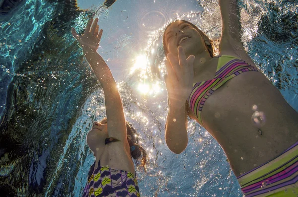 I bambini nuotano in piscina o in mare sott'acqua, le ragazze attive felici si divertono sott'acqua, lo sport per bambini in vacanza con la famiglia — Foto Stock