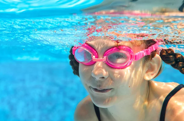 Enfant nage dans la piscine sous l'eau, fille active heureuse dans les lunettes s'amuse sous l'eau, sport enfant en vacances en famille — Photo