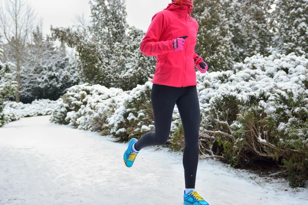 Zima w parku: szczęśliwa kobieta lekkoatletka jogging w śniegu, odkryty sport i fitness koncepcja — Zdjęcie stockowe