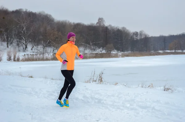 Winter met in forest: gelukkig vrouw loper joggen in de sneeuw, buiten sport en fitness concept — Stockfoto