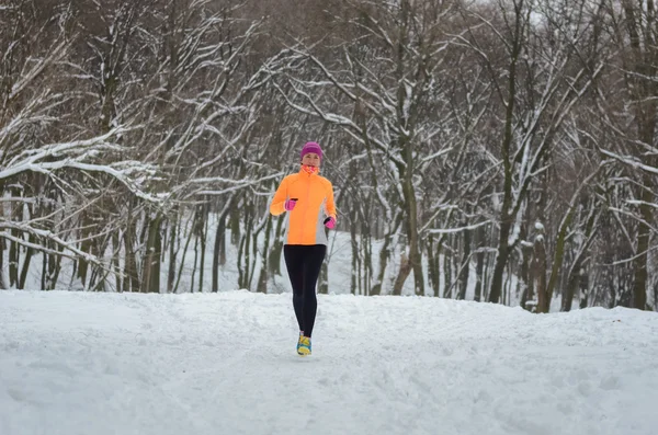 Zimní běh v lese: šťastná žena běžec běhání ve sněhu, venkovní sport a fitness koncept — Stock fotografie