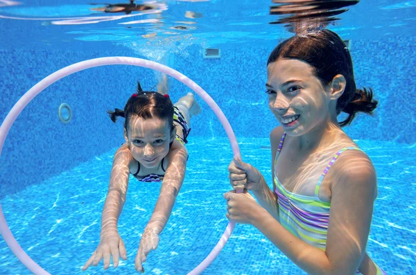 Crianças nadam na piscina subaquática, meninas ativas felizes se divertir debaixo d 'água, crianças esporte em férias em família — Fotografia de Stock