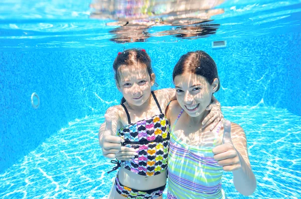 Los niños nadan en la piscina bajo el agua, las niñas activas felices se divierten bajo el agua, los niños se divierten en vacaciones familiares —  Fotos de Stock