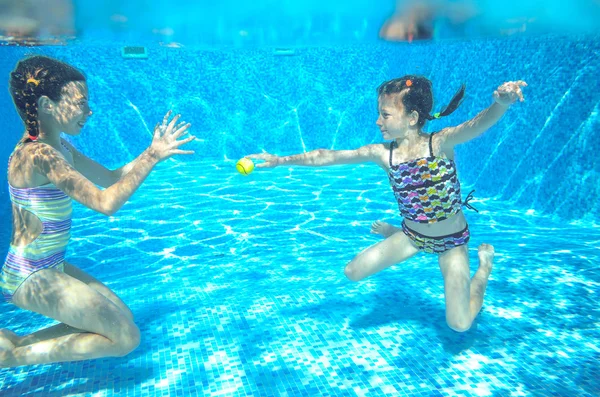 Heureux les enfants actifs nagent dans la piscine et jouent sous l'eau, les filles plongent et s'amusent, les enfants en vacances d'été, concept de sport — Photo