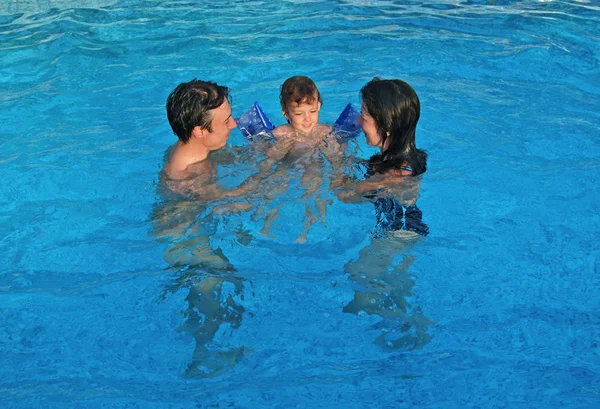 Семья с ребенком развлекается в бассейне — стоковое фото