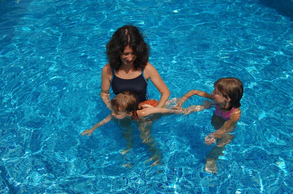 Família feliz se divertindo na piscina nas férias de verão, mãe e filhos — Fotografia de Stock