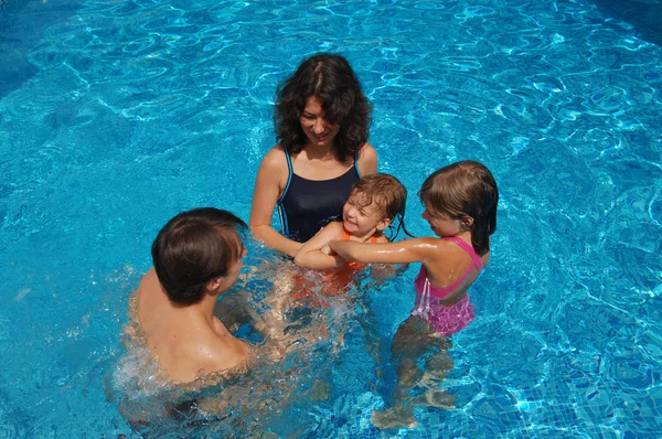 Mutlu bir aile eğlenceli yüzme havuzunda yaz tatile sahip. — Stok fotoğraf