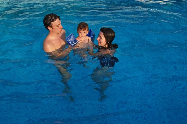 Familie med barn have det sjovt i swimmingpoolen - Stock-foto