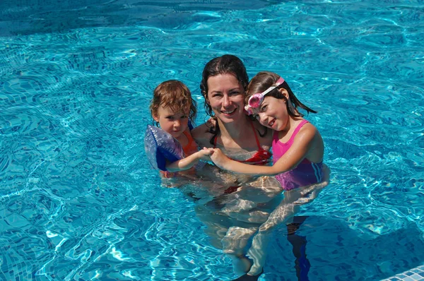 Familia feliz divirtiéndose en la piscina en las vacaciones de verano, madre e hijos —  Fotos de Stock