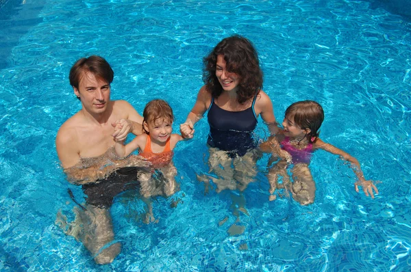 Šťastná rodina baví v bazénu na letní dovolenou — Stock fotografie