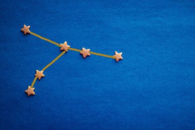 Temmuz 'da doğanlar için yıldız falı, Kanser takımyıldızı. Mavi arkaplanda küçük bir yıldız işareti. Üst görünüm, boşluğu kopyala. Resim yazar tarafından yapılmıştır..