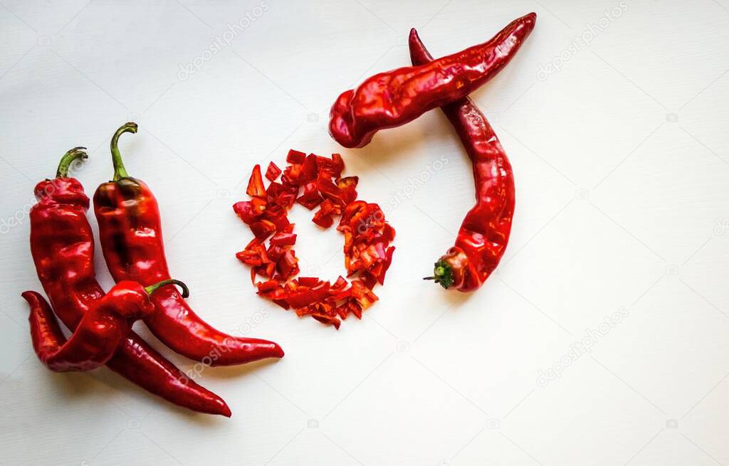 Red pods of bitter pepper are lined hot. Light background, copy seismic, top view.