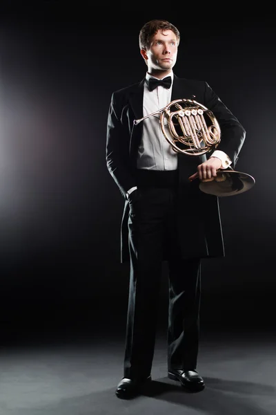 Elegante hombre en esmoquin con cuerno francés — Foto de Stock