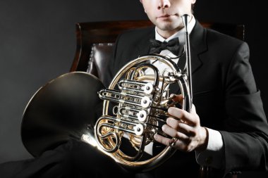 Fransız kornosu oyuncu ile müzik enstrümanı