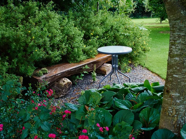 Bella panca in legno in un giardino — Foto Stock