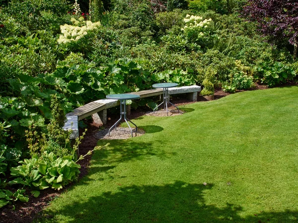 Mooie houten bankje in een tuin — Stockfoto