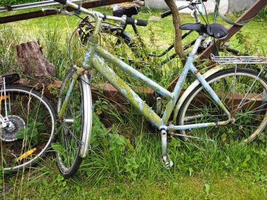Paslı eski bir çift kullanılmamış bisiklet arka bahçedeki tarlaya düşmesin diye.
