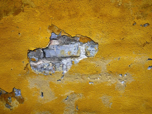 空旷而质感的黄色石膏墙面 后面是旧砖 带有复制粘贴图形和文字空间的原始背景 — 图库照片