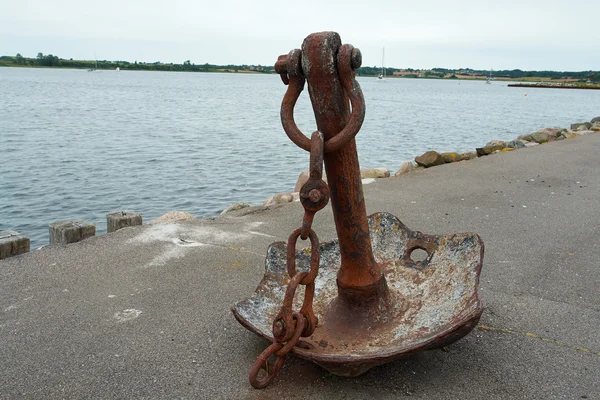 Old anchor on a pier — Stock Photo, Image