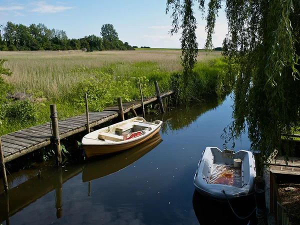 Tranquil escena pequeños botes bote en un río — Foto de Stock