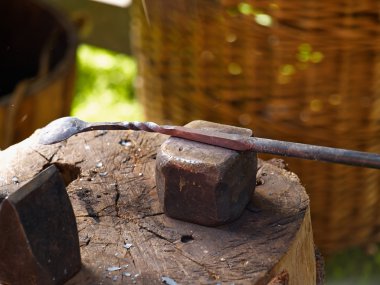 Demir örs üzerinde çalışan demirci