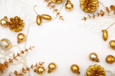Altın takılar, meşe palamutları ve çam kozalaklarıyla zarif bir kış geçmişi var. Beyaz minimalist Noel kopyalama alanı.