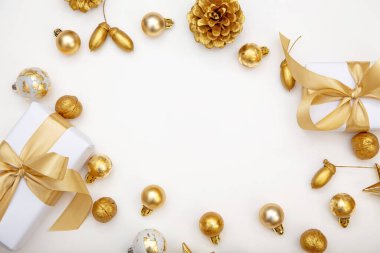 Altın Noel dairesi zarif hediyeler, çam kozalakları ve bej yüzeyinde ip ışıkları ile yatıyordu. Web tasarımı, reklamcılık veya kutlama amaçlı selamlama düzenleri için uygun kopya alanı olan rahat kompozisyon.