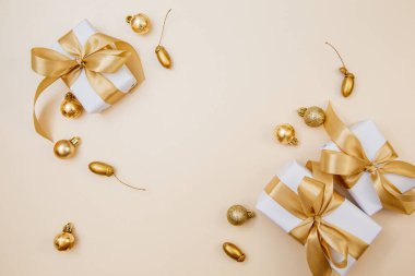 Beyaz hediyeler, altın kurdeleler ve parlak süslemelerle süslü zarif bir arka plan. Reklam, web sitesi başlıkları ve sosyal medya paylaşımları için ideal.